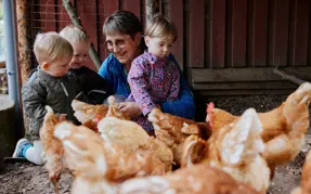 Nr Vissing: Mor og børn sammen med en flok høns