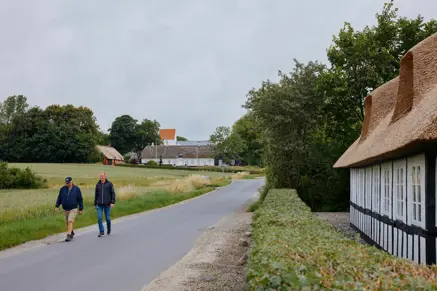 2 personer går en tur med kirken i baggrunden